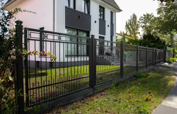 Zaunbau Berlin mit Schmiedezaun vor weißem Haus